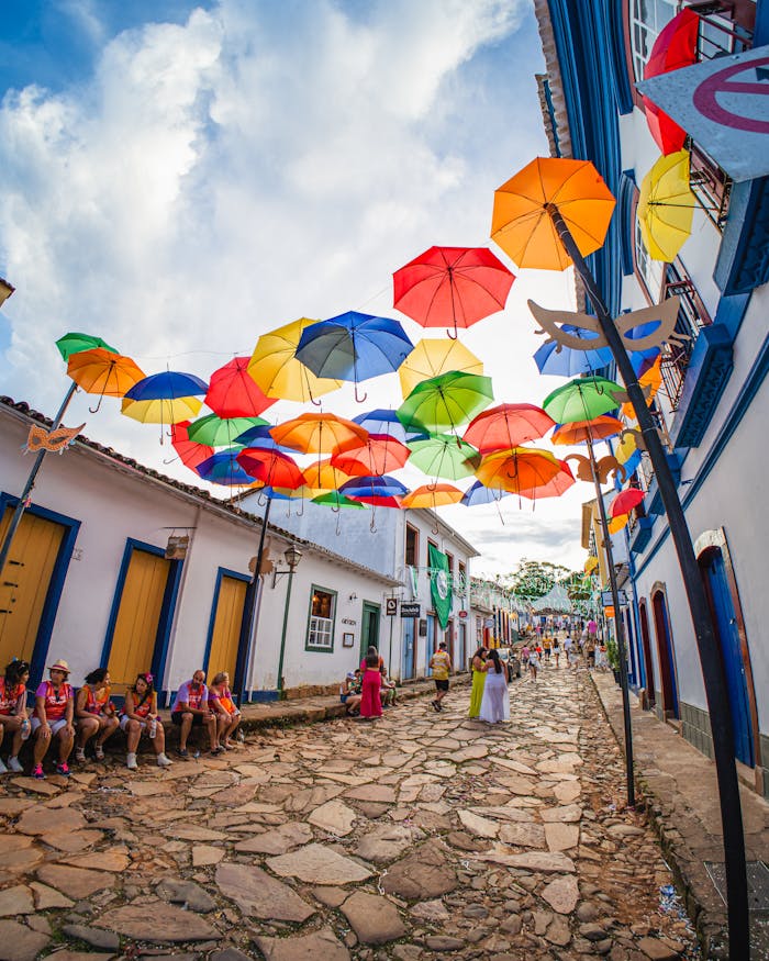 Vibrant umbrellas adorn a historic street in Tiradentes, Brazil, during a festive celebration.